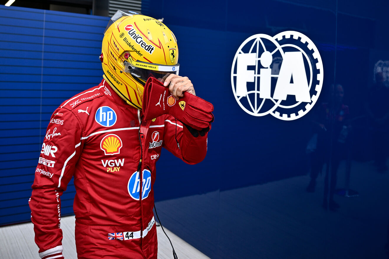 Ferrari driver Lewis Hamilton of Britain walks back to his pits after...