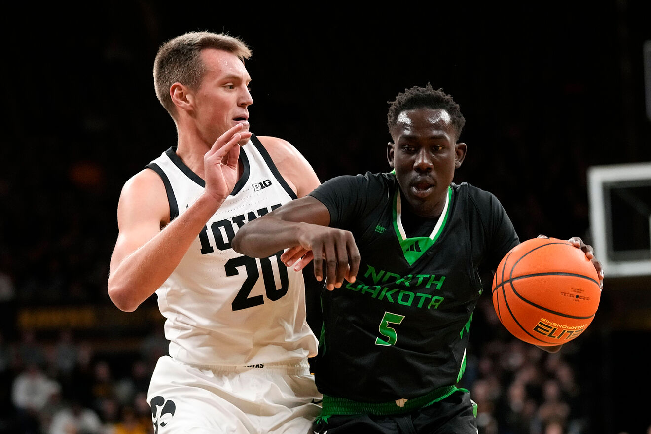 North Dakota forward Deng Mayar (5) drives past Iowa forward Payton...